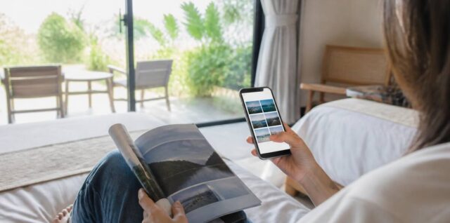 Een reiziger die vakantieopties vergelijkt op een smartphone naast reisdocumenten en een notitieblok
