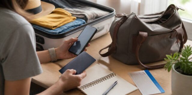 Passpoort, telefoon en checklist op een reistaamblad als voorbereiding voor vertrek